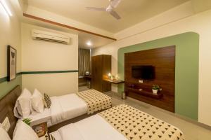 a hotel room with two beds and a television at Olive Hotel Electronic City by Embassy Group in Bengaluru