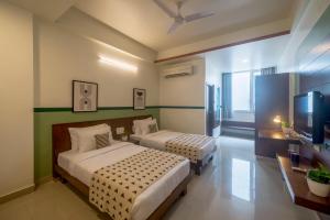 a hotel room with two beds and a television at Olive Hotel Electronic City by Embassy Group in Bengaluru