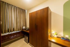 a room with a wooden cabinet and a window at Olive Hotel Electronic City by Embassy Group in Bengaluru