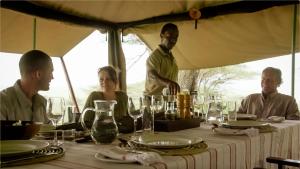 Un groupe de personnes assises autour d'une table dans l'établissement Esirai Camp, à Sinoni