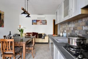 cocina y sala de estar con mesa y sillas en Villa Isabel, en Cala Gonone