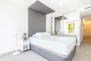 ein weißes Schlafzimmer mit einem großen Bett und einem Fenster in der Unterkunft Seimar 1-8 Apartment Levante Beach in Benidorm