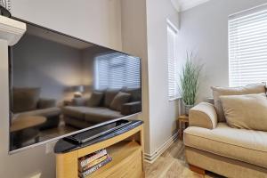 Modern Spacious 2 Bedroom Apartment in Brentwood في Shenfield: غرفة معيشة مع تلفزيون بشاشة مسطحة كبيرة
