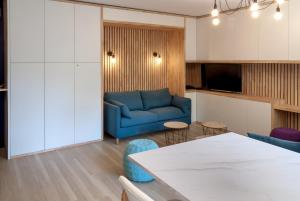 a living room with a blue couch and a table at 8 min de la plage, 2 de la gare, 15 de St-Nazaire in La Baule
