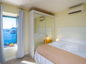 a bedroom with two beds and a view of the ocean at Villa Lola in Lopud