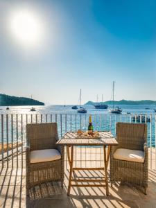 una mesa y sillas en una terraza con vistas al agua en Villa Lola, en Lopud Island
