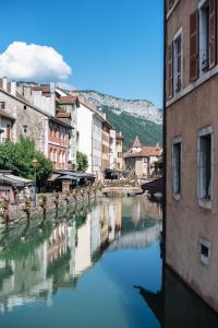 - une vue sur une rivière dans une ville avec des bâtiments dans l'établissement Auberge du Lyonnais, à Annecy