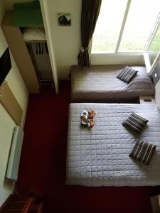 um pequeno quarto com 2 camas e uma janela em Hotel Du Golf em Cabourg