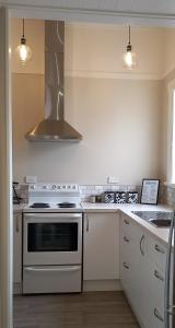 a kitchen with white cabinets and a stove top oven at Character 2-Bedroom Unit in Masterton