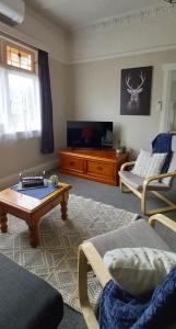 a living room with a coffee table and a tv at Character 2-Bedroom Unit in Masterton