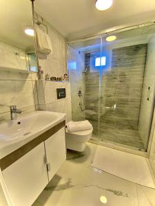 a bathroom with a toilet and a sink and a shower at Port Mansion in Marmaris