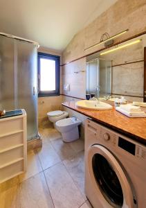 a bathroom with a sink and a washing machine at Murphy Holiday Home - Residenza Aldo Moro 02 in La Maddalena