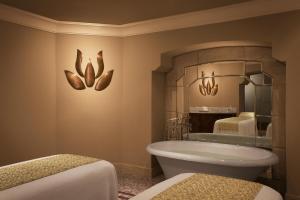 a bathroom with two beds and a tub and a mirror at Umaid Bhawan Palace Jodhpur in Jodhpur