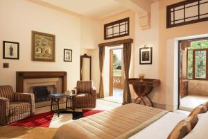 a living room with a bed and a fireplace at Umaid Bhawan Palace Jodhpur in Jodhpur