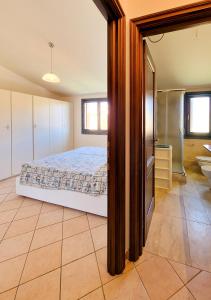 a bedroom with a bed and a bathroom at Murphy Holiday Home - Residenza Aldo Moro 02 in La Maddalena