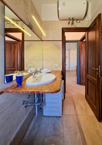 uma casa de banho com um lavatório e um espelho grande em Residenza Aldo Moro 02 em La Maddalena