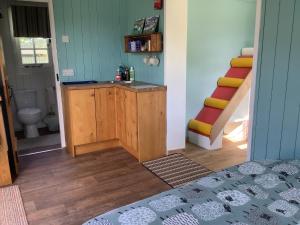 a room with a bathroom with a staircase and a bed at Shepherds Hut (Benny's) in Cullompton