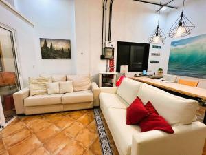 una sala de estar con 2 sofás blancos y almohadas rojas en ALCAMAR Habitaciones en Pisos compartidos cerca al Mar!, en Alcalá