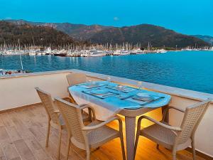 a table and chairs on a deck with a marina at Port Mansion in Marmaris