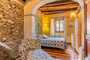 a bedroom with two beds and a stone wall at Villa Camelia Bianca in Barga