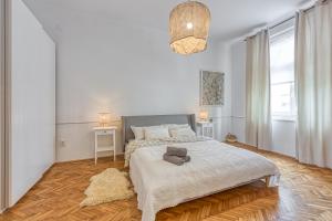 a white bedroom with a large bed and two windows at Spacious Apartment In Heart Of Zagreb - Happy Rentals in Zagreb