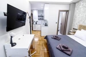1 dormitorio con 1 cama, escritorio y TV en LK Apartment -A- Metro Larissis 6' Walk - Athens, en Atenas