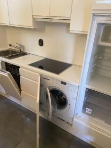 a kitchen with a washer and dryer in a cabinet at Flat in Garden Residence resort, Malcesine, Italy (with heated pool) in Malcesine