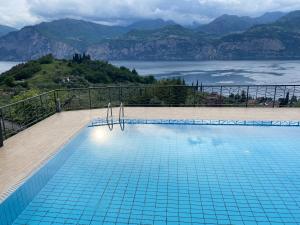 a swimming pool with a view of a mountain at Flat in Garden Residence resort, Malcesine, Italy (with heated pool) in Malcesine