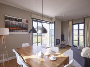 un salon avec une table et un canapé dans l'établissement Reetland am Meer - Premium Reetdachvilla mit 3 Schlafzimmern, Sauna und Kamin F09, à Dranske