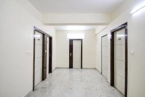 an empty corridor of a building with doors and tile floors at FabHotel Trishiv - Newtown Kolkata in Kolkata +25 photos