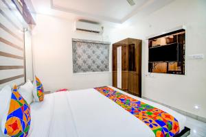 a bedroom with a bed and a tv on the wall at FabHotel Trishiv - Newtown Kolkata in Kolkata