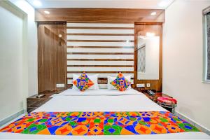 a bedroom with a large bed with a colorful comforter at FabHotel Trishiv - Newtown Kolkata in Kolkata