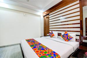 a bedroom with a bed with colorful pillows at FabHotel Trishiv - Newtown Kolkata in Kolkata