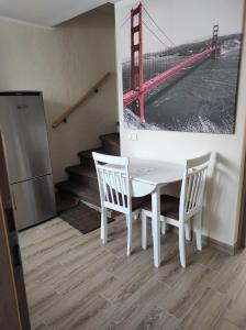 猶爾巴卡的住宿－Apartamentai G&G，一张白色的桌子和椅子,上面有金门桥的照片