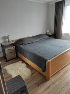 1 dormitorio con cama, mesa y ventana en Apartamentai G&G en Jurbarkas