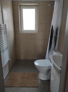 uma casa de banho com um WC, um lavatório e uma janela em Apartamentai G&G em Jurbarkas