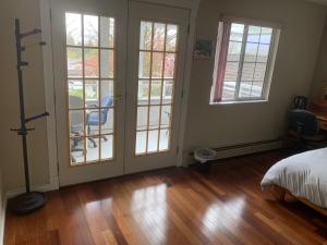a bedroom with french doors and a wooden floor at SFU comfortable house in Burnaby
