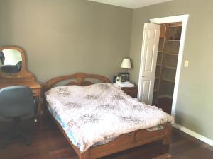 a bedroom with a bed and a desk and a chair at SFU comfortable house in Burnaby