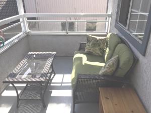 a balcony with a couch and a table and a window at SFU comfortable house in Burnaby