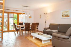 ein Wohnzimmer mit einem Sofa und einem Tisch in der Unterkunft Ferienpark Freesenbruch Reihenhaus 8b - Bivalvia in Zingst