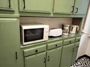 a microwave sitting on a counter in a kitchen at Le nid douillet Vintage idéal pour 2 jusqu'à 4 in La Bourboule