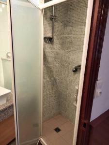 a shower with a glass door in a bathroom at Le nid douillet Vintage idéal pour 2 jusqu'à 4 in La Bourboule +6 photos