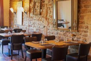 a restaurant with wooden tables and chairs and a mirror at Auberge du port in Bazeilles