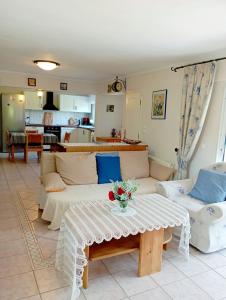 a living room with a couch and a table at Naturstein-Mediterranhaus mit Gartenblick in Flogita