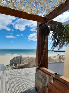 uma vista para a praia a partir do alpendre de uma casa de praia em Golden Paradise 007 Helio 66 em Cap d'Agde