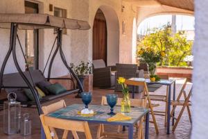um pátio com duas mesas e cadeiras e um guarda-sol em Villa Oidor - Cilento em Marina di Ascea