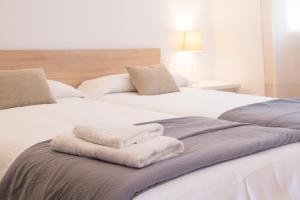 Duas camas brancas sentadas uma ao lado da outra num quarto em Grupoandria Aparthotel Club Andria em Cala Santandria