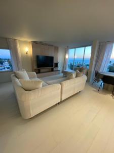 a living room with a white couch and a television at best sea view boutique two bedrooms in Herzliya