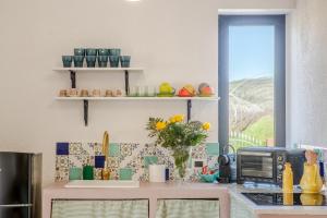 cocina con encimera, microondas y ventana en Villa Oidor - Cilento, en Marina di Ascea