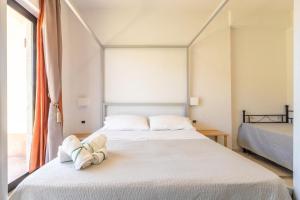 Un dormitorio con una gran cama blanca y una ventana en Villa Oidor - Cilento, en Marina di Ascea